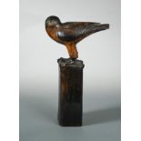 A carved wood model of a falcon, modelled standing upon a post 50cm (20in)