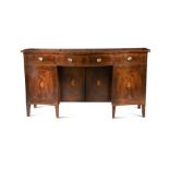 A George III mahogany kneehole sideboard, with three drawers above four cupboard doors, on short