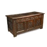 A late 17th century oak coffer, the three panelled top above a carved front and arcaded frieze,