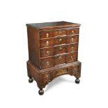 A William & Mary period oak chest of four long drawers, with panelled centres, brass drop handles