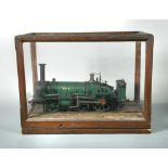A mid-Victorian live steam model locomotive with open cab, painted in green and black livery and