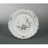 An 18th century French Marseille faience plate, enamelled with two Chinese men seated in a garden,
