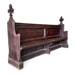 A 17th century oak Cathedral pew, removed from Ely cathedral and reduced in length to sit eight