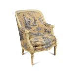 A French Louis XVI revival tub armchair, the painted and leaf carved frame upholstered in a blue and