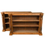 A pair of William IV style figured oak open front bookcases, flanked by lapit carved and reeded