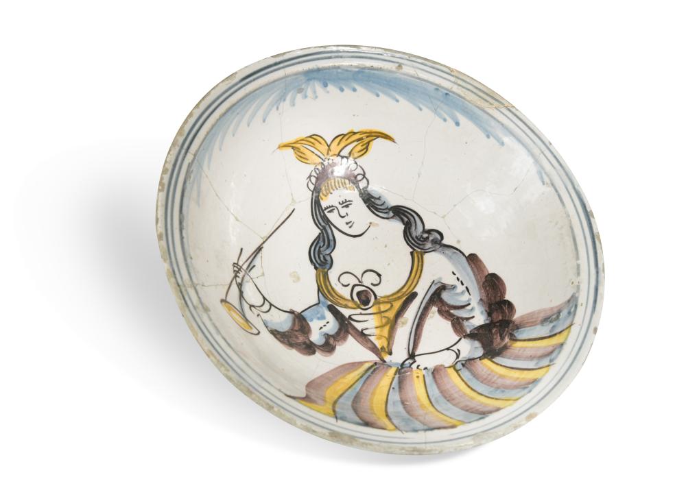 An 18th century Delft polychrome bowl, decorated with the figure of a woman holding a trumpet, in