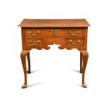 An 18th century oak lowboy, fitted three drawers, with brass handles, a fret carved apron and on