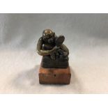 A small Bergman bronze model of a monkey or ape with a comb and a hand mirror, modelled seated