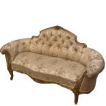 A late mid-Victorian gilt framed sofa with raised foliate cresting and curved ends, 92cm (36in) high