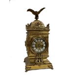 A brass cased mantle clock with an eagle finial and dial enamelled with Arabic numerals, to an 8-day