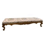 A giltwood framed long footstool, on swept legs, 26 x 126 x 34cm (10 x 49.5 x 13.5in)