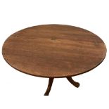 A limed oak circular kitchen table with hinged folding top, on shaped feet, together with four