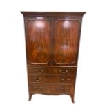A small mahogany press with dentil moulded cornice, with shelved interior, on swept bracket feet,