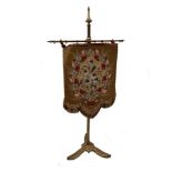 A late Victorian gilded brass-framed banner screen, with bead and needlework hanging, on tripod base