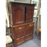 An 18th century oak cupboard, the recessed upper part with dentil cornice and enclosed by a pair