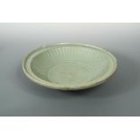 A Longquan celadon dish, Ming dynasty, the shallow rounded sides rising from a short tapering foot