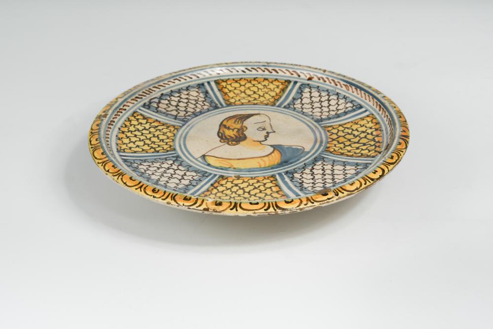 An 18th century Italian maiolica tazza, decorated to the centre with a portrait of a young lady,