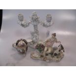 A pair of continental porcelain white glazed two-branch figural candlesticks; a pair of Dresden