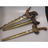 Three early 20th century kriss, with plain wooden deity handles