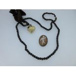 A garnet bead necklace together with a heart-shaped locket and a cameo pendant / brooch