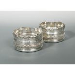 A pair of Victorian high sided silver plated bottle coasters, decorated with a convex band of