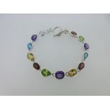 A modern multi gem set bracelet, composed of oval or pearshaped facetted amethyst, peridot,