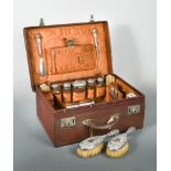 An Edward VII travelling dressing case, the exterior in brown textured leather with monogrammed lid,