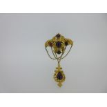A Victorian cabochon garnet brooch with pendant drop, of ornate scroll, bead and foliate form,
