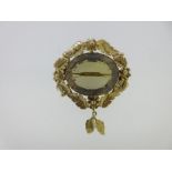 A Victorian smoky citrine brooch with foliate and floral mount, the oval cut light brownish yellow
