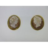 A pair of Victorian shell cameo earclips, each depicting a head in profile, book-matched, of a