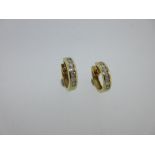 A pair of 18ct gold and channel set diamond earhoops, each earring a 3mm wide uniform hoop with