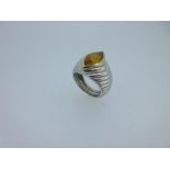 A French platinum and 18ct gold ring set with a citrine, the navette shaped cabochon deep golden