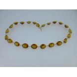 A necklace of golden citrines, the twenty three slightly graduating oval cut citrines, spectacle set
