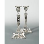 A pair of silver plated column candlesticks, in the neo classical style, the square base with