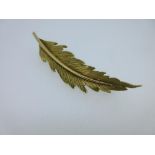 Garrard & Co - An 18ct gold feather brooch, the gently curved and realistically textured feather