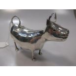 A continental metalwares Schuppe style cow creamer, possibly Dutch, of plain form with hinged saddle