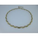 A 9ct gold chain necklace of navette shaped links, each link a textured navette beneath a fine