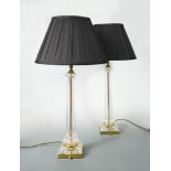 A pair of modern glass columnar table lamps, the facetted columns with stepped square foot with