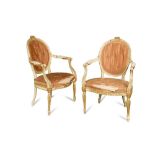 A pair of George III painted and parcel gilt salon chairs, each with moulded frames and carved in