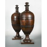 A pair of modern George III style mahogany knife urns, with rising tops, half fluted carved bodies
