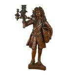 An Italian carved walnut figure in late 17th century costume, probably late 19th century, holding