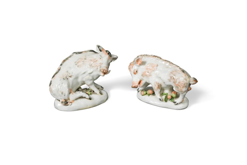 A pair of porcelain models of 'Florentine' boars, on oval bases encrusted with foliage, 14cm long (