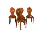 A set of four George III mahogany hall chairs, painted with Boars head crests, possibly for Col. Sir