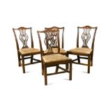 A set of four early George III mahogany dining chairs, with serpentine crest rails and pierced