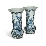 A pair of Dutch Delft blue and white vases, 19th century, one painted with a gentleman climbing a