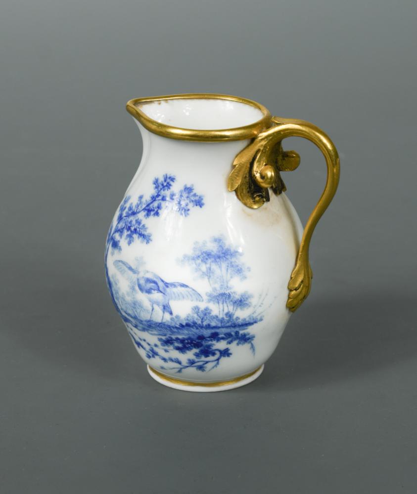 A Sevres ormolu mounted cream jug, painted by Francois Jospeh Aloncle in camaieu bleu with vignettes