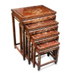 A Chinese nest of four hardwood and mother of pearl tables, the tops inlaid with fanciful birds