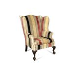A George III style wing back chair, upholstered in a striped fabric, on carved cabriole legs 113 x