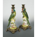 A pair of gilt metal mounted porcelain parrot candlesticks, 20th century, each modelled as a