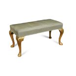 A George II style gilt framed longstool, on cabriole legs and pad feet, upholstered in blue silk